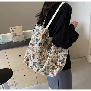 Detail of canvas tote bag with colorful butterfly patterns and woven side label
