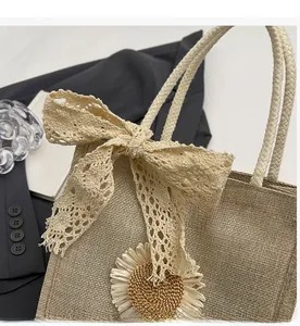 Detail of straw handbag with lace bow, sunflower decor and woven rope handle
