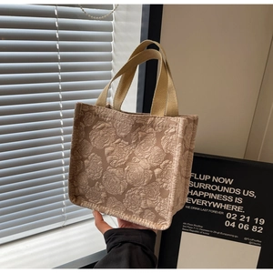 Gros plan sur le tissu jacquard rose vintage et les poignées tissées d'un grand cabas