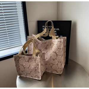 Détails de deux sacs cabas rose poudré avec motif floral en relief et anses beiges