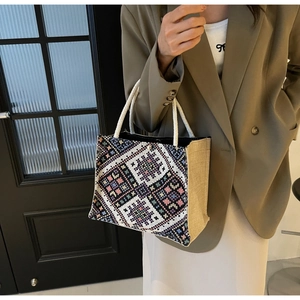 Close-up of geometric embroidery and woven rope handle on the ethnic crossbody bag
