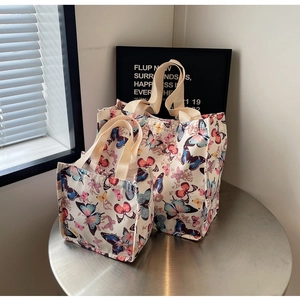 Set of two white canvas tote bags with colorful butterfly prints in large and small sizes