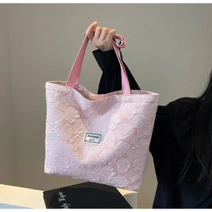 Detailed texture of pink 3D rose jacquard canvas tote with white label