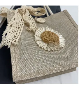 Detail of jute tote bag featuring floral lace bow, crochet sunflower, and wooden button