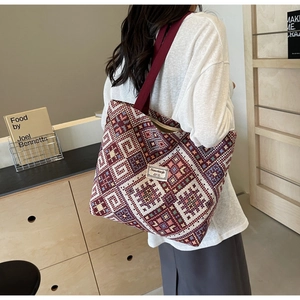 Cabas ethnique en tricot avec motifs géométriques et bandoulière rouge portée