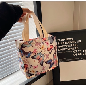Detail of high-density canvas tote featuring vibrant colorful butterfly prints and woven handles