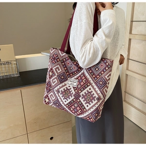 Détail du sac cabas tissé ethnique avec bandoulière rouge et motifs géométriques