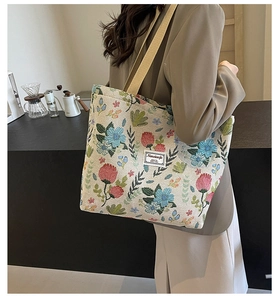 Detail of floral jacquard canvas tote bag with khaki nylon strap and side label tag