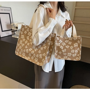 Detail view of khaki canvas tote bags with white 3D floral patterns for women