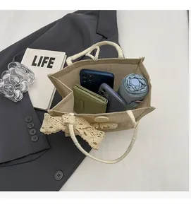 Interior storage view of beige woven tote showing phone, wallet and folding umbrella