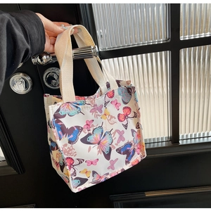 Close-up of lightweight canvas tote bag featuring vibrant all-over butterfly prints