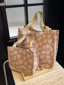 Pink canvas tote bag set with white heart patterns in large and small sizes