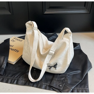 Détail du sac papillon blanc avec texture plissée et boucle argentée réglable