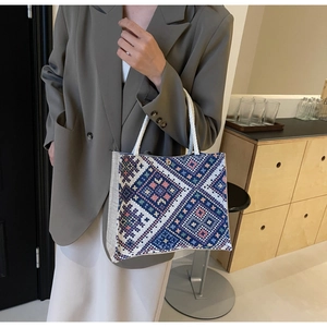 Close-up of geometric ethnic pattern on cotton linen tote bag with woven rope handle