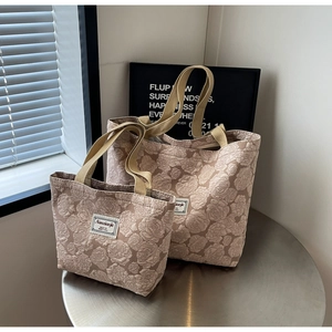 Detail of elegant champagne tote bag featuring 3D rose jacquard floral pattern embroidery