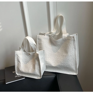Detailed comparison of large and small white tote bags with textured jacquard fabric