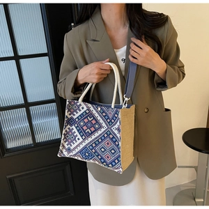 Ethnic woven tote bag detail showing geometric diamond patterns and rope knot handles
