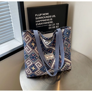 Gros plan détaillé sur le motif ethnique tissé et l'écusson de marque du sac en toile