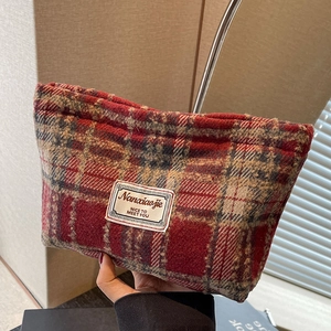 Close-up of red and beige checkered tweed makeup bag with Nanxiaojie woven label
