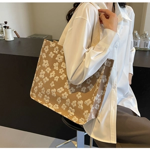 Lifestyle shot of large floral canvas tote bag with beige straps in a cafe setting