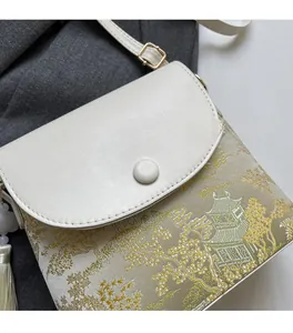 Détail du tissu jacquard aux motifs de pavillons et pompons sur un sac seau beige