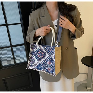 Close-up of ethnic print tote bag with geometric embroidery and braided rope handles
