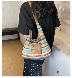 Detail of colorful striped woven tote bag with brown leather strap and small pouch