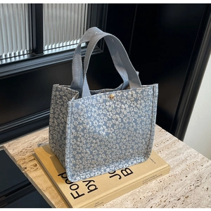 Close-up of light blue floral jacquard tote bag with textured embossed flower pattern