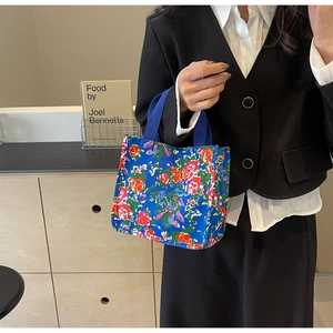 Détail du sac cabas en toile à fleurs bleues avec imprimés et poignées robustes
