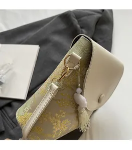 Détails des finitions métalliques dorées et du tissu jacquard du mini sac bandoulière