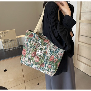 Detail of floral jacquard canvas tote bag with thick strap shown on shoulder