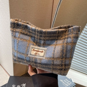 Detail of blue and brown checkered wool cosmetic bag with a vintage textile texture