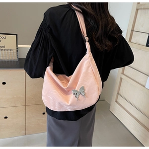 Détail du sac demi-lune rose avec boucle papillon argentée porté par le mannequin