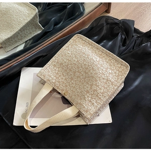 Détail du cabas jacquard beige avec broderies florales 3D et ornements dorés élégants