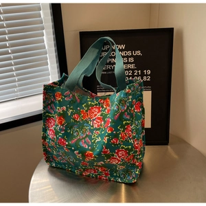 Détail d'un cabas en toile à motif floral vintage avec des poignées tissées robustes
