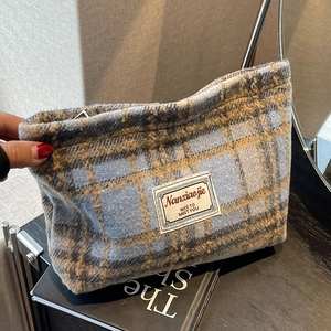 Detail of blue and brown checkered fabric bag with a woven label and texture