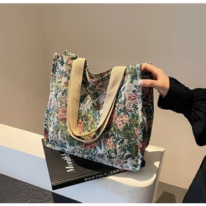 Detailed close-up of retro floral jacquard weave and thick beige woven strap on a tote bag