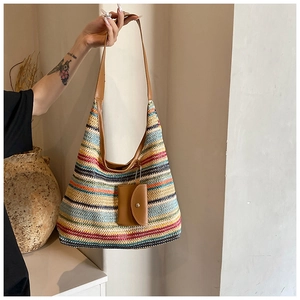 Detail of large woven tote bag with multi-color stripes and leather shoulder strap