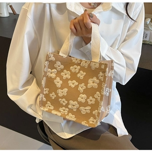 Detail of 3D floral embroidery on brown canvas tote bag with retro gold buckle