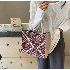 Detailed macro view of woven ethnic patterns and thick rope handle on tote bag