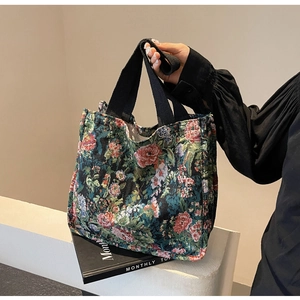 Detailed close-up of a floral jacquard tote bag with ethnic woven patterns and black straps