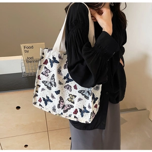 Canvas tote bag with colorful butterfly prints shown in a warm lifestyle setting