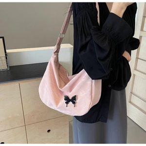 Détail du sac hobo rose avec breloque papillon fluide et bandoulière réglable et large