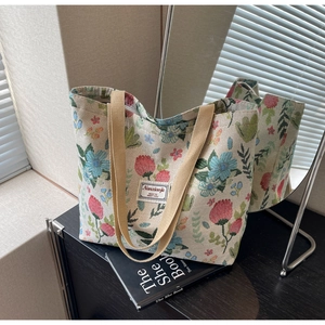 Detail of floral jacquard tote bag featuring vintage pattern and brown woven handles