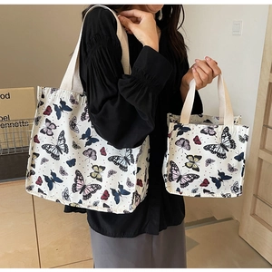 Detail showing two-piece canvas tote bag set with colorful butterfly prints and thick straps