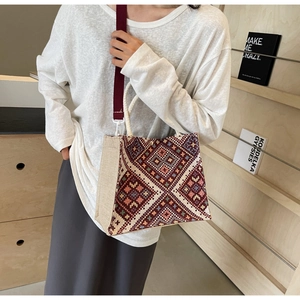 Detail of colorful geometric woven tote bag with detachable red canvas shoulder strap