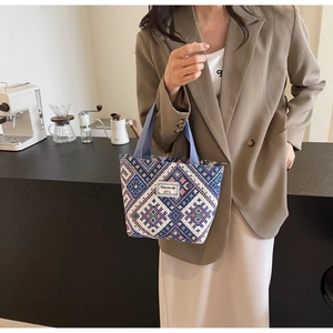 Gros plan du motif géométrique au point de croix sur un sac cabas en toile ethnique