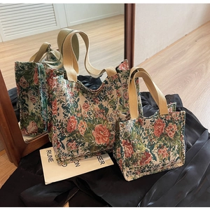 Detail of floral tapestry tote bag set with rose embroidery and beige webbing straps