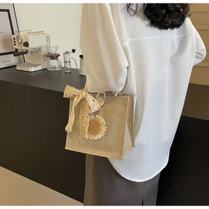 Détail d'un sac en jute avec fleur de tournesol et nœud en dentelle dans un café
