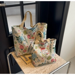 Detailed comparison of two sizes of vintage floral jacquard tote bags with woven labels